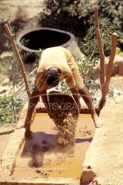 Image du Maroc Professionnelle de  Un ouvrier verse l’argile brut dans un bassin, pour l'imprégner d’eau dans les ateliers de la Vallée Chaâba à Safi, Samedi 30 Août 1997. (Photo / Abdeljalil Bounhar)